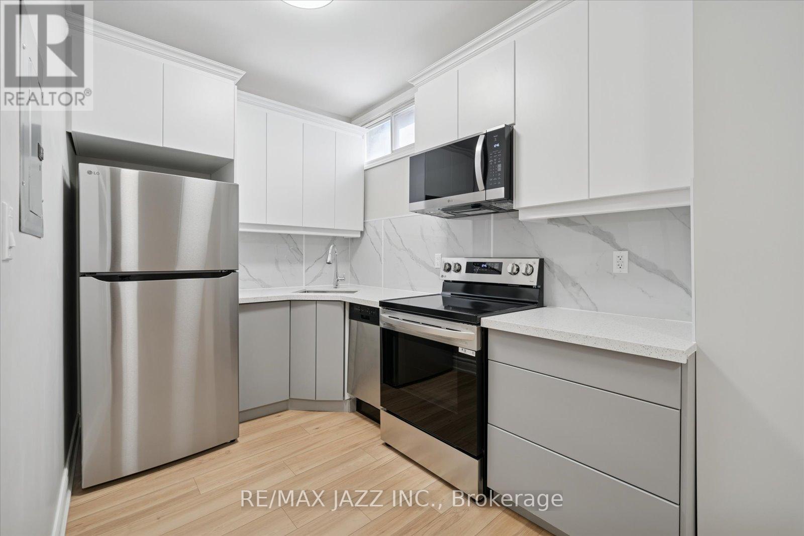 A kitchen with white cabinets and a stainless steel refrigerator.