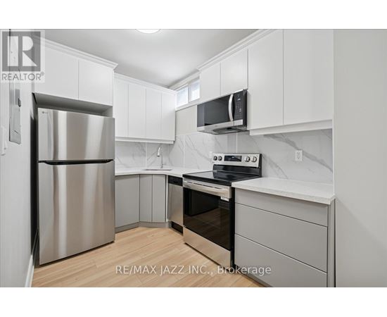 A kitchen with white cabinets and a stainless steel refrigerator.