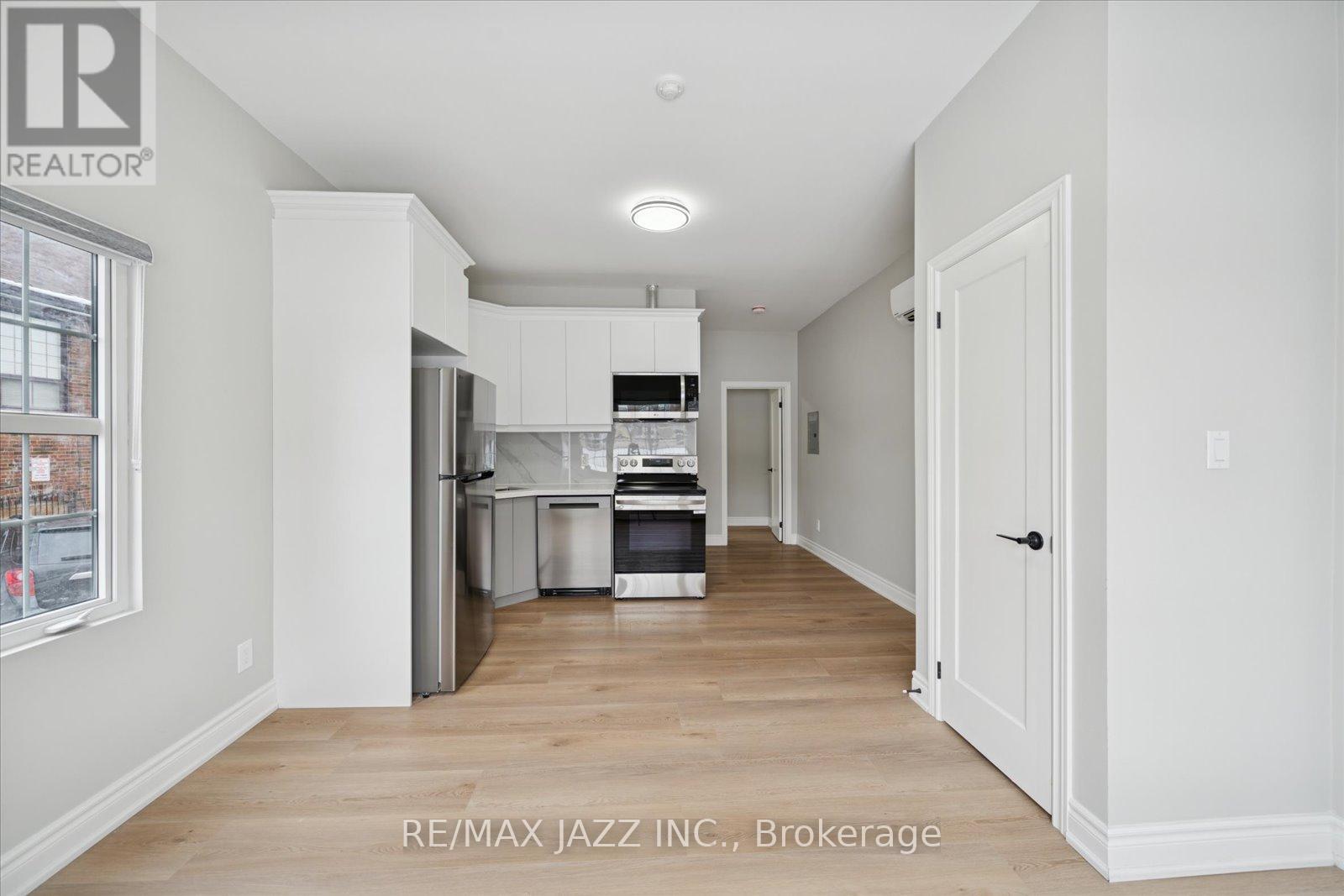 A kitchen with white cabinets and a refrigerator.