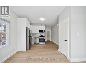 A kitchen with white cabinets and a refrigerator.