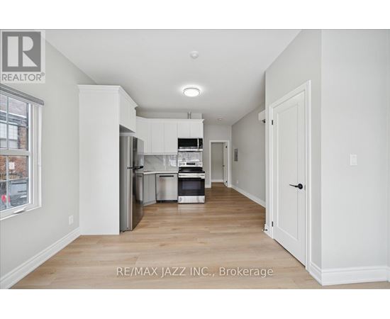 A kitchen with white cabinets and a refrigerator.