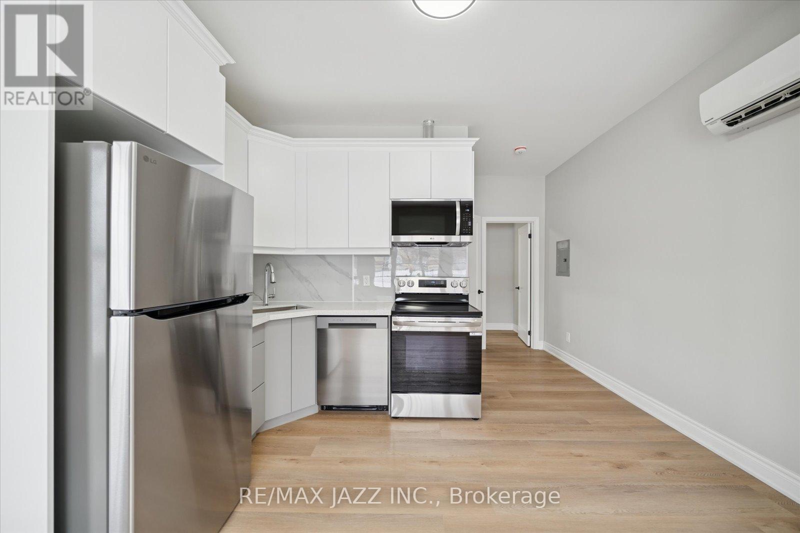 A modern kitchen with white cabinets and stainless steel appliances.