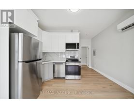 A modern kitchen with white cabinets and stainless steel appliances.