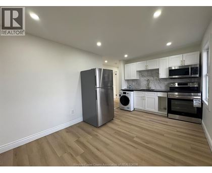 A kitchen with a refrigerator, microwave, oven, and dishwasher.