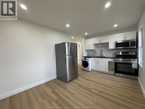 A kitchen with a refrigerator, microwave, oven, and dishwasher.