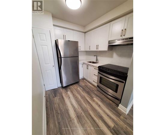 A kitchen with a stainless steel refrigerator and oven.