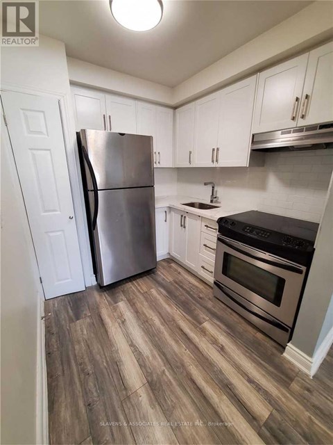 A kitchen with a stainless steel refrigerator and oven.