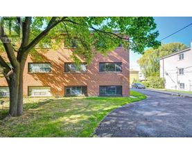 A red brick building with a tree in front of it.