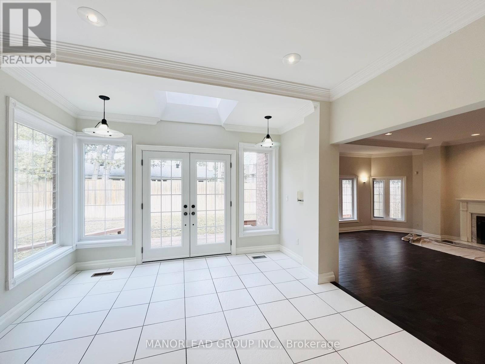 A spacious living room with a fireplace and a skylight.