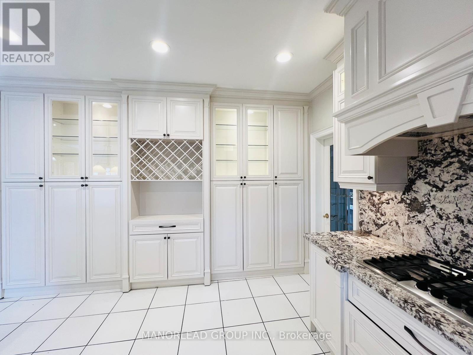 A kitchen with white cabinets and granite countertops.