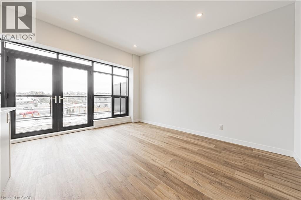 A large empty room with wooden floors and a sliding glass door.