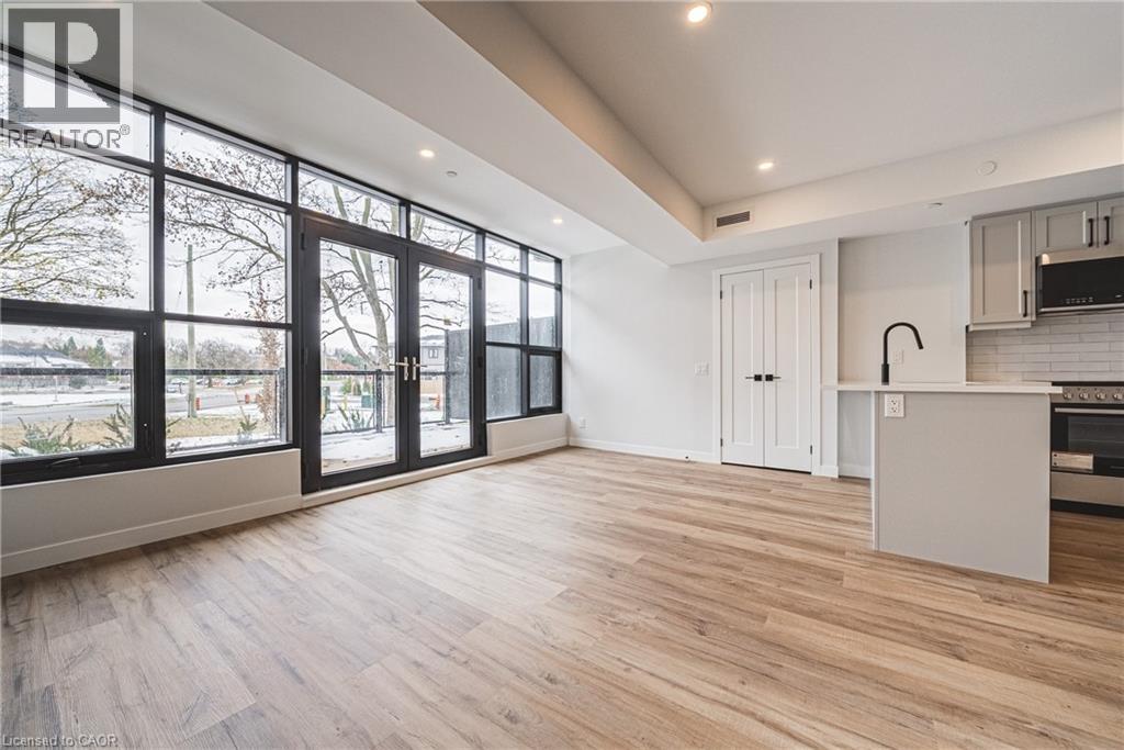 A modern kitchen with a wooden floor and white walls.