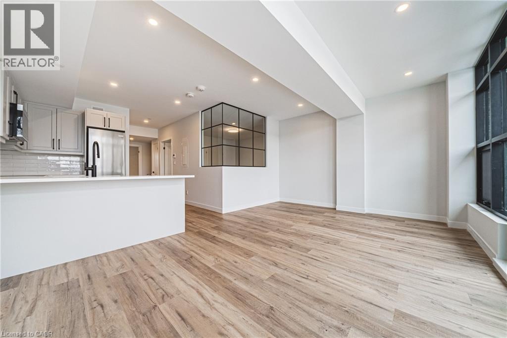 A modern kitchen with wooden floors and white walls.