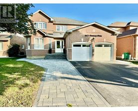 A brick house with a driveway in front of it.