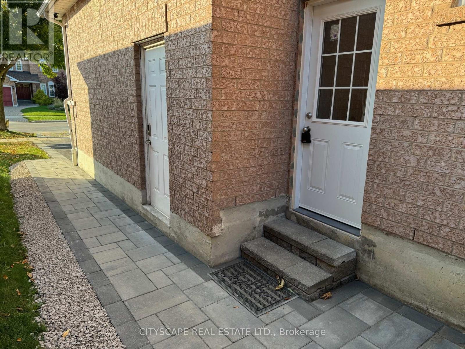 A house with a white door and a brick wall.