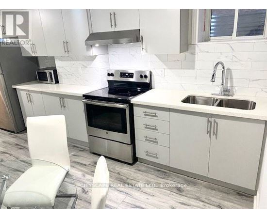 A modern kitchen with white cabinets and a marble backsplash.