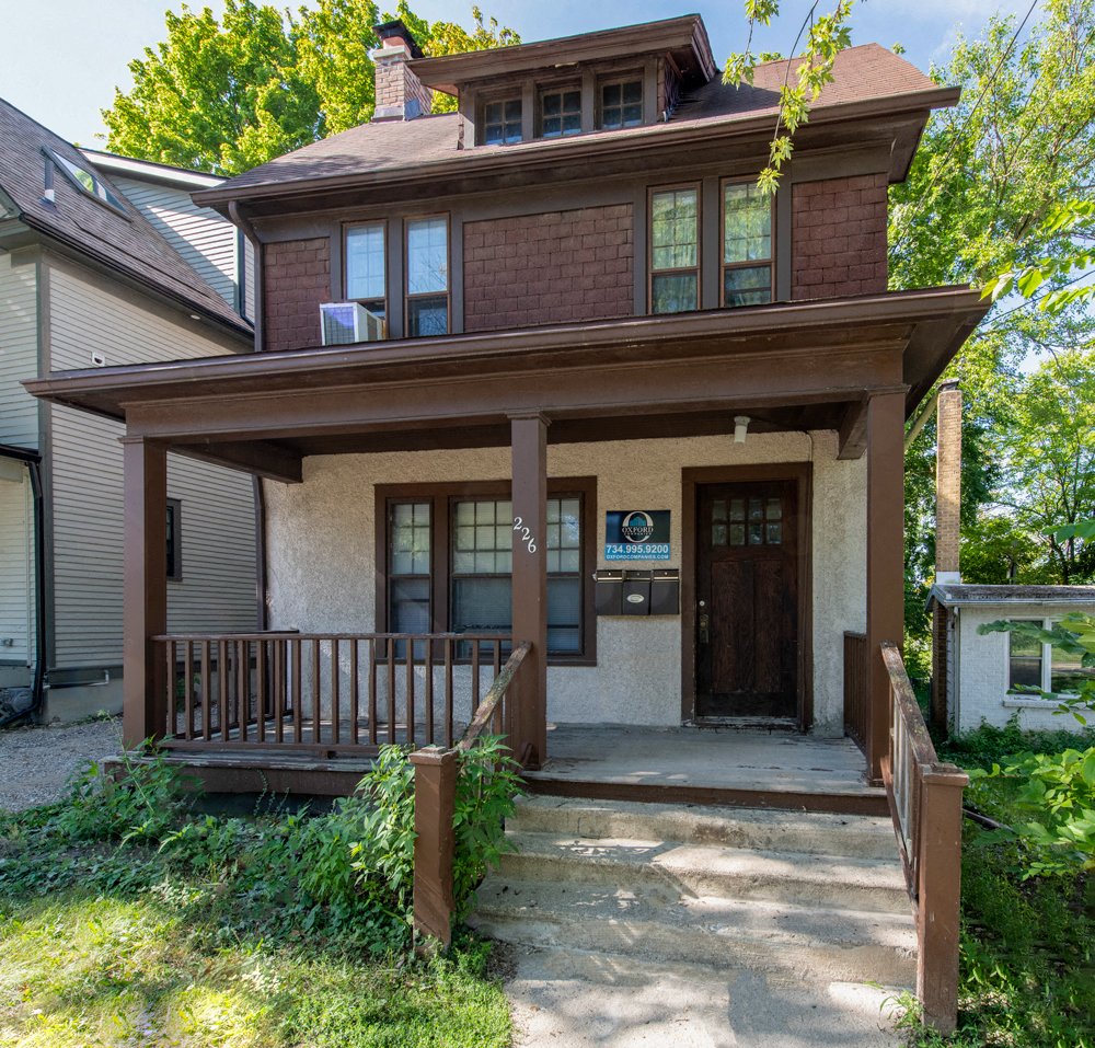the front porch of a house with a wooden deck