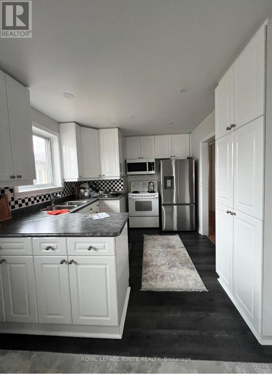 A kitchen with white cabinets and a black countertop.