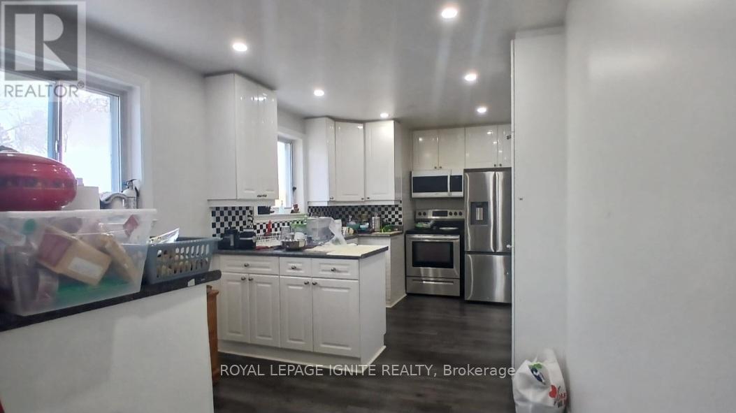 A kitchen with white cabinets and a stainless steel refrigerator.