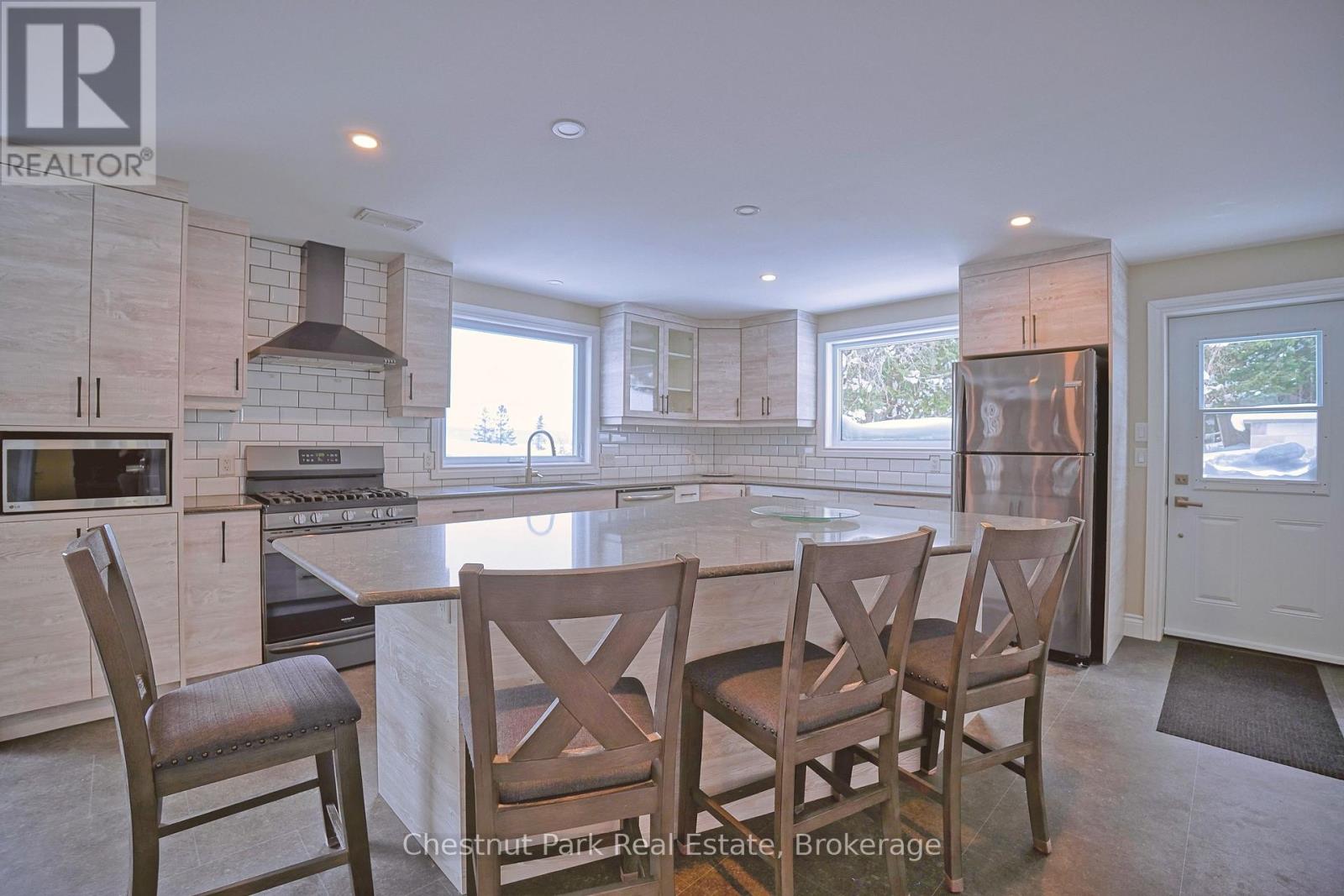 A kitchen with a table and chairs in front of a window.