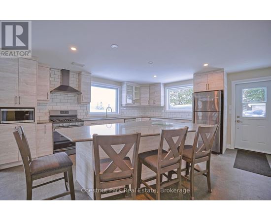 A kitchen with a table and chairs in front of a window.