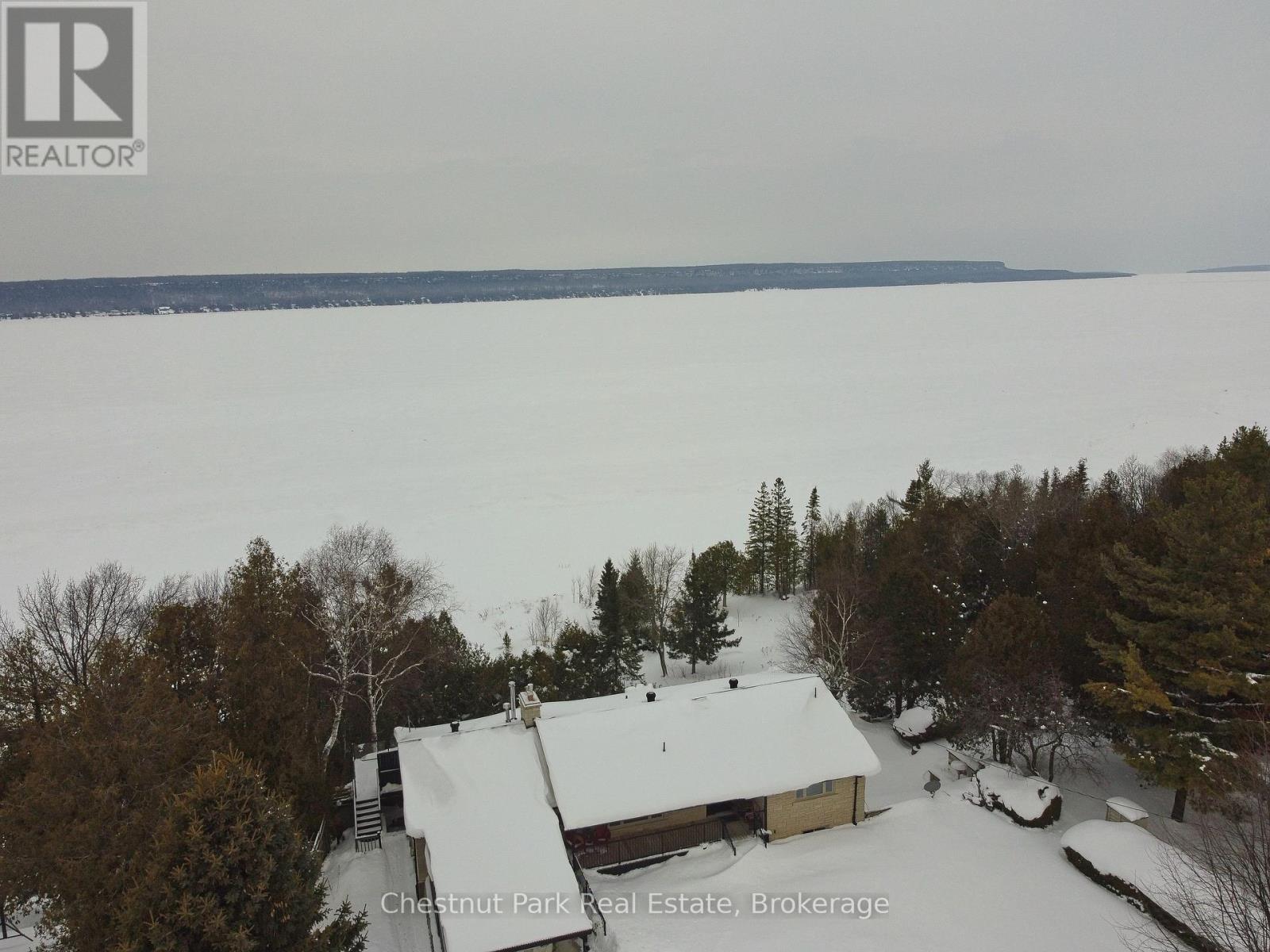 A house in a snowy landscape with trees around it.