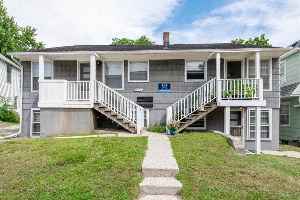 the front of a house with stairs and a porch