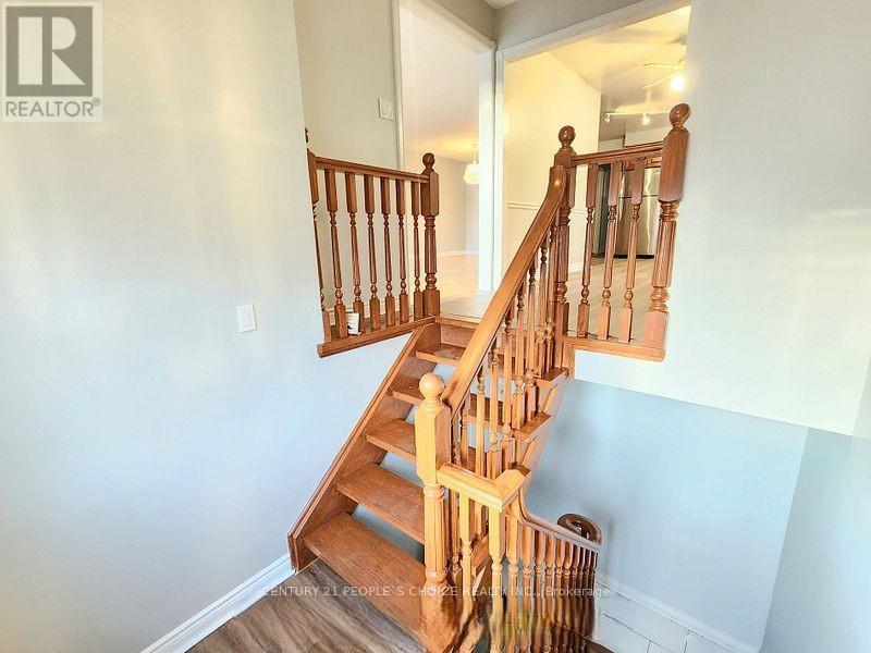 A wooden staircase with a railing leads up to a doorway.