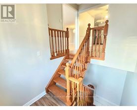 A wooden staircase with a railing leads up to a doorway.