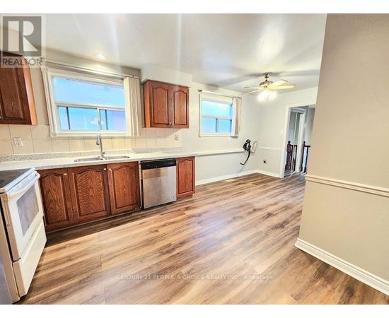 A kitchen with wooden cabinets and a white stove top oven.