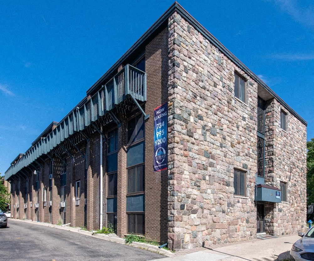 the side of a brick building with a blue sign