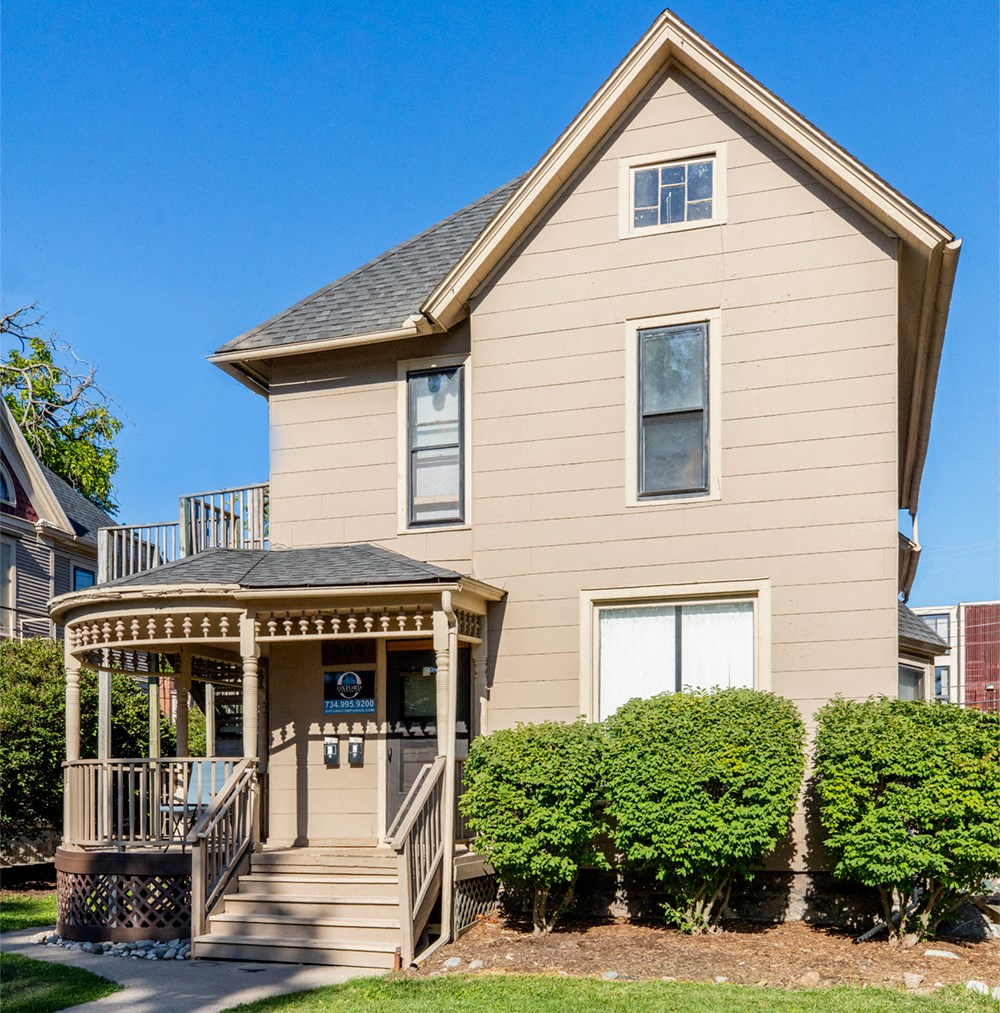 the front of a house with a porch and a gazebo