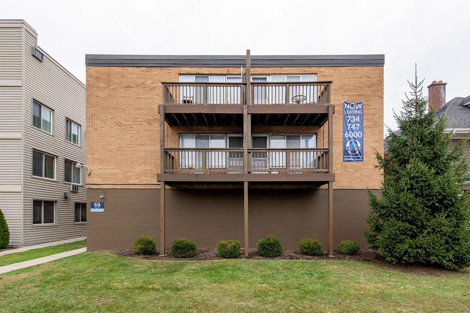 A building with a balcony and a sign that says "NOW" on it.