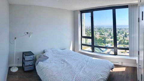 A bedroom with a large bed and a view of the city.