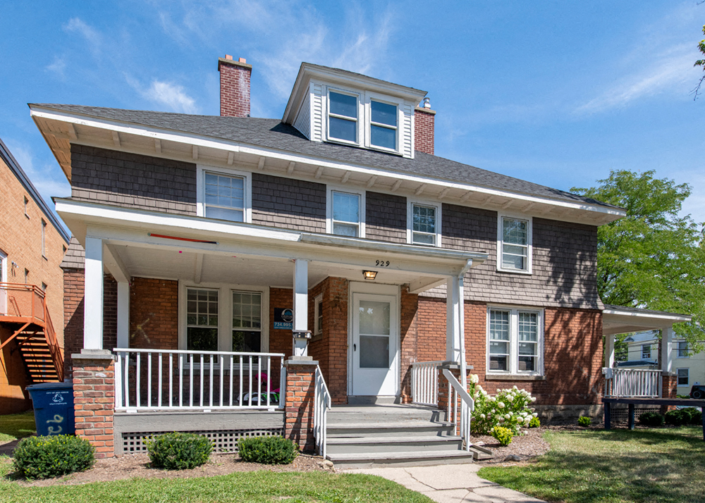 A two-story house with a front porch and a white door.