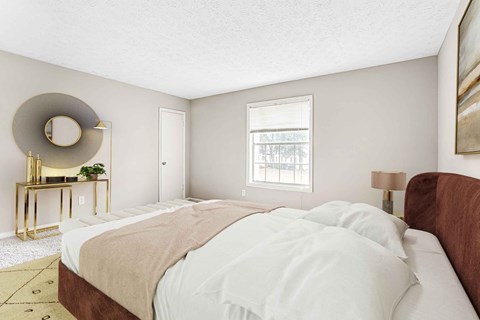 A bedroom with a large bed and a round mirror on the wall.