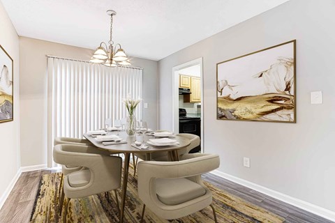 A dining room with a round table and chairs.