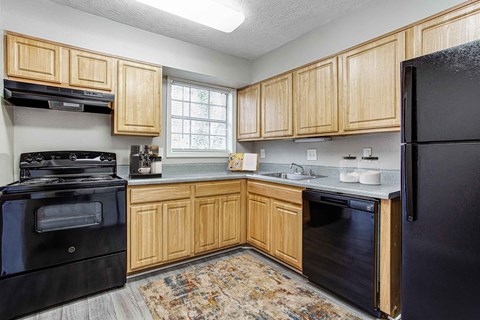 A kitchen with wooden cabinets and black appliances.