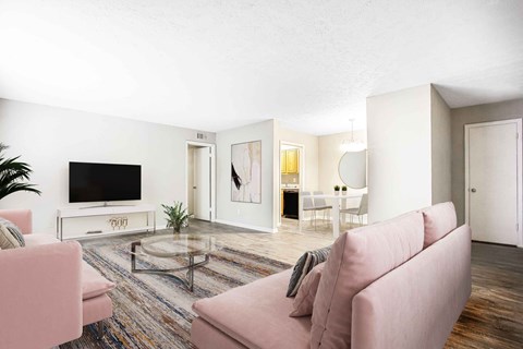 A living room with a pink couch and a television.