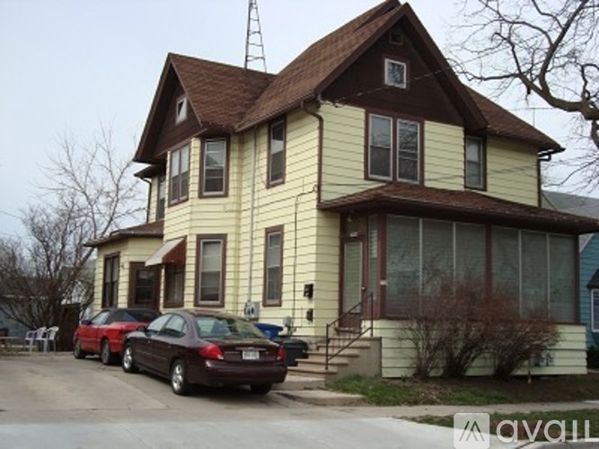 A house with a brown roof and a car parked in front.