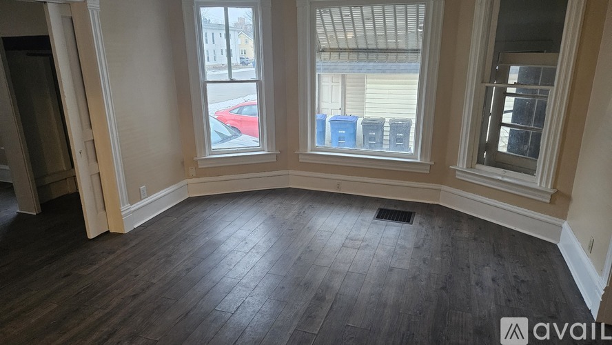 A room with wooden floors and two windows.