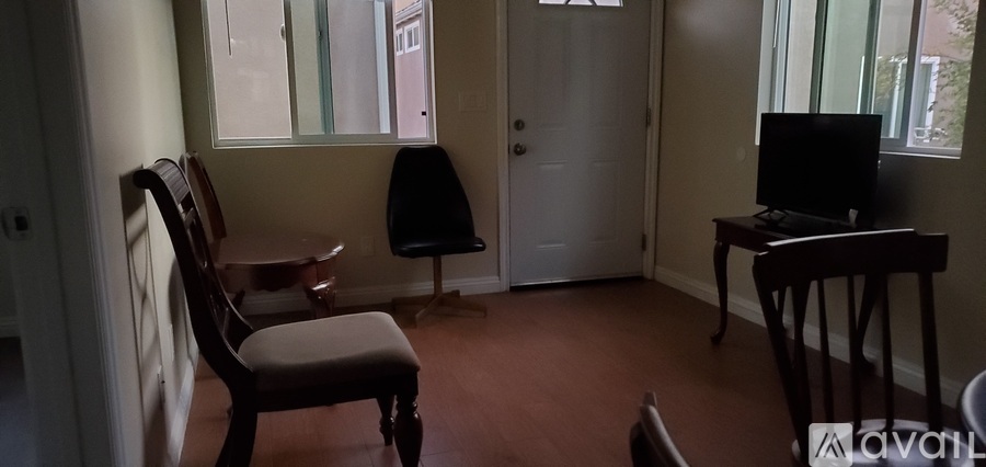 A room with a chair, a table, and a television.