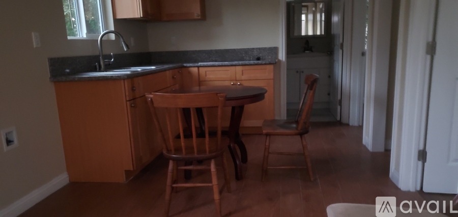 A kitchen with a table and chairs.