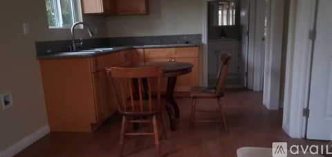 A kitchen with a table and chairs.