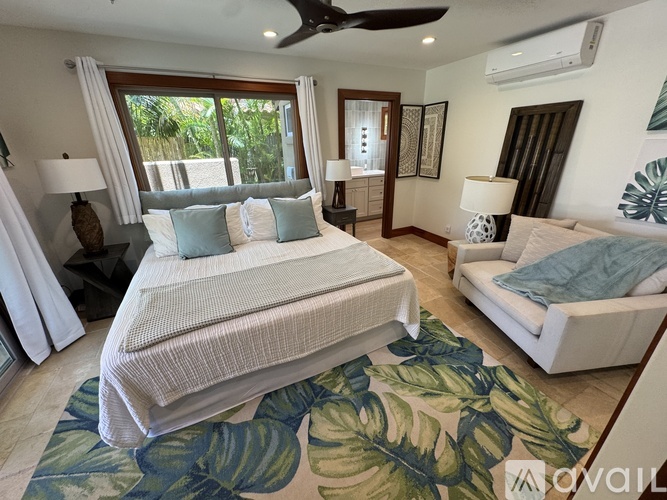 A bedroom with a large bed and a ceiling fan.