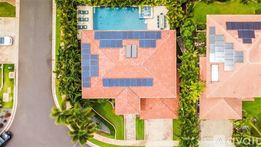 A bird's eye view of a house with a swimming pool and solar panels.
