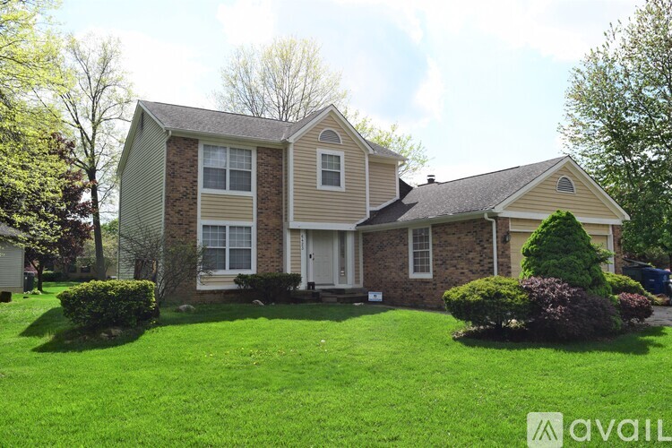 A house with a well-kept lawn in front of it.