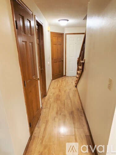 A hallway with wooden doors and a staircase.
