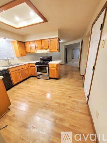 A kitchen with wooden cabinets and a black stove top oven.