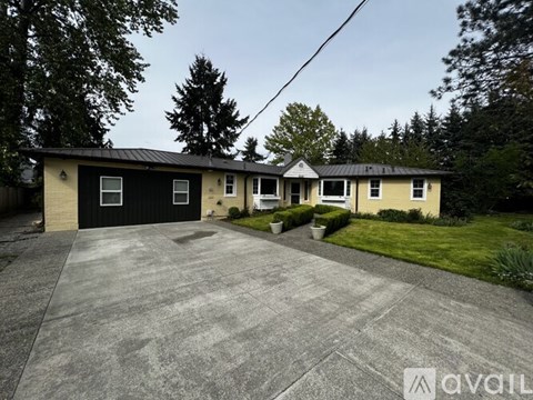 A house with a black garage door is for sale.